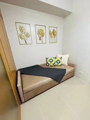 a bed in a room with pictures on the wall at Vibrant Pasay City Apartment for Rent - Perfect Home Base front of Mall of Asia in Manila