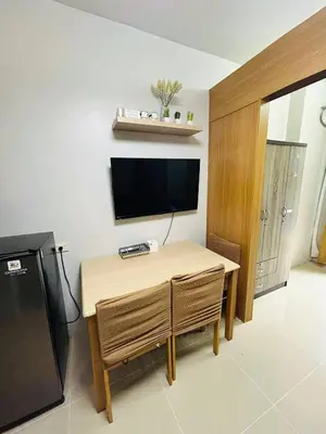 a room with a table and a television and a table and chairs at Vibrant Pasay City Apartment for Rent - Perfect Home Base front of Mall of Asia in Manila