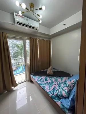 a bedroom with a bed and a large window at Vibrant Pasay City Apartment for Rent - Perfect Home Base front of Mall of Asia in Manila