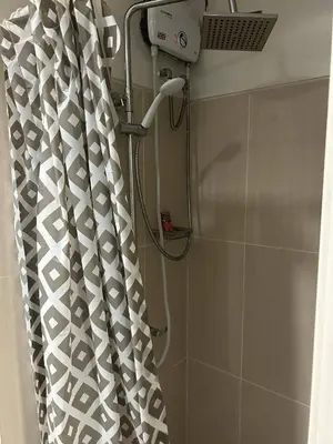 a shower with a shower curtain in a bathroom at Vibrant Pasay City Apartment for Rent - Perfect Home Base front of Mall of Asia in Manila