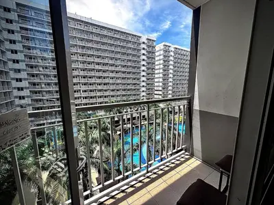 a balcony with a view of a large building at Kempt Pasay City Apartment for Rent - Perfect for Short-Term Stay front of MOA in Manila