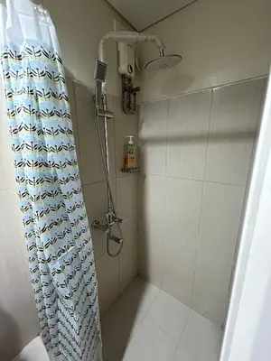 a shower with a shower curtain in a bathroom at Kempt Pasay City Apartment for Rent - Perfect for Short-Term Stay front of MOA in Manila