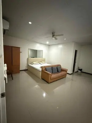 a bedroom with a bed and a couch in it at La Belladoza near Airport in Manila