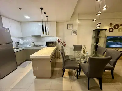a kitchen with a glass table and chairs in a kitchen at Shell Residence Pasay MOA 2br by G&K in Manila