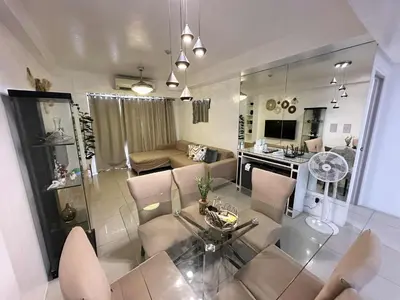a living room with a couch and a table and chairs at Shell Residence Pasay MOA 2br by G&K in Manila