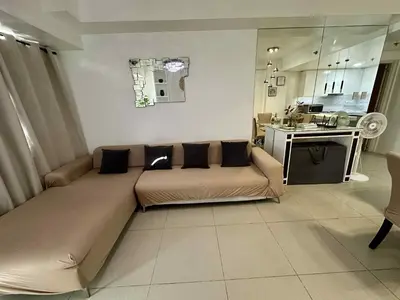 a living room with a couch and a kitchen at Shell Residence Pasay MOA 2br by G&K in Manila