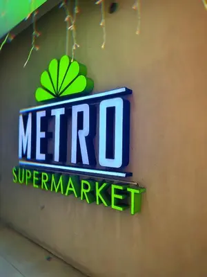 a sign for a meto supermarket on a wall at Kai cabins WALKING DISTANCE NAIA 3 AIRPORT NEWPORT CITY in Manila