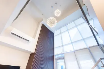 a room with a large window and chandeliers at BGC Spacious 1BR Loft Uptown in Manila