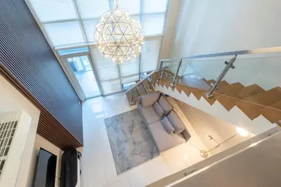 a living room with a couch and a chandelier at BGC Spacious 1BR Loft Uptown in Manila