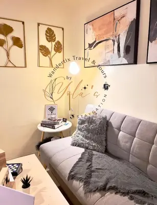 a living room with a couch and a table with a laptop at Yola's Staycation - Jazz Residences Makati City in Manila