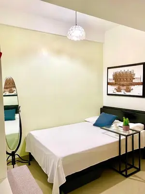 a bedroom with a bed and a table at Cordial Condo in Manila