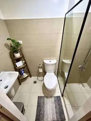 a bathroom with a toilet and a glass shower at Cordial Condo in Manila