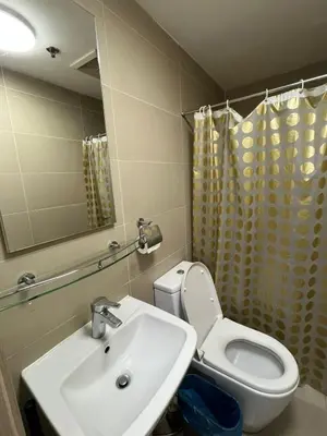 a bathroom with a sink and a toilet and a mirror at The Serenity Tower 3114 in Manila