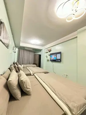 a hospital room with three beds and a tv at Shell Residence Pasay MOA with 2 Beds by G&K in Manila