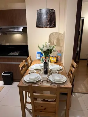 a dining room table with plates and flowers on it at 1-Bedroom Condo - Stunning Sunset at the City in Manila
