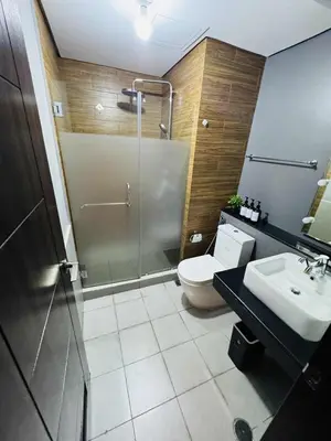 a bathroom with a shower and a toilet and a sink at 1-Bedroom Condo - Stunning Sunset at the City in Manila
