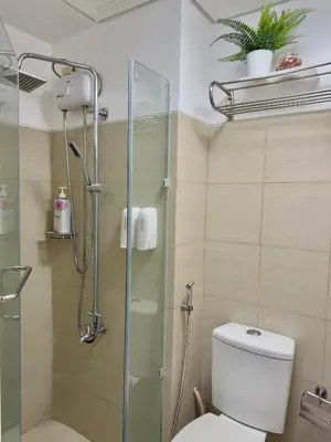 a bathroom with a toilet and a glass shower at Le Luna Unit - Affordable Staycation near Airport & MOA with pool by Voyage Vista - Azure & Shore Staycation in Manila
