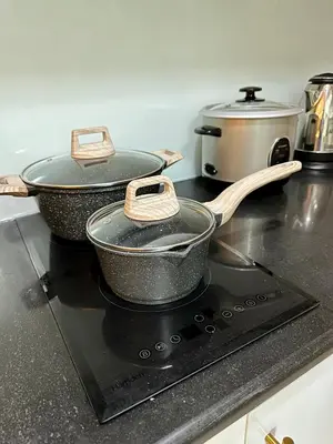 two pots and pans sitting on top of a stove at Le Luna Unit - Affordable Staycation near Airport & MOA with pool by Voyage Vista - Azure & Shore Staycation in Manila