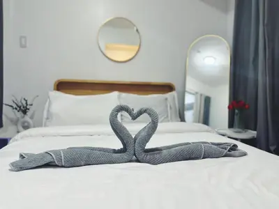 two towels in the shape of a heart on a bed at Staycation in Marymount in Manila