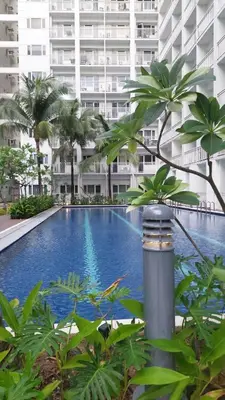 a large swimming pool in front of a large building at Staycation in Marymount in Manila