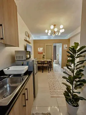 a kitchen with a sink and a dining room at Staycation in Marymount in Manila
