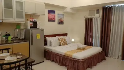 a small room with a bed and a kitchen at McKinley Hills Taguig Haven in Manila