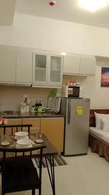 a small kitchen with a table and a refrigerator at McKinley Hills Taguig Haven in Manila