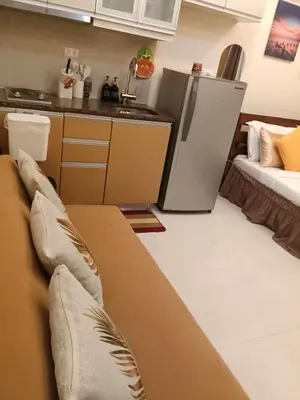 a living room with a couch and a kitchen at McKinley Hills Taguig Haven in Manila
