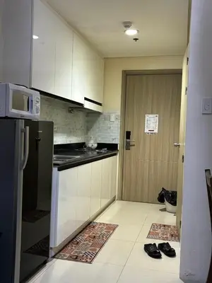 a kitchen with a refrigerator and a door to a room at Seaside Stay in Manila