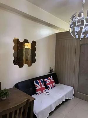 a living room with a black couch and a table at Seaside Stay in Manila