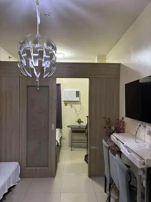 a dining room with a table and a chandelier at Seaside Stay in Manila