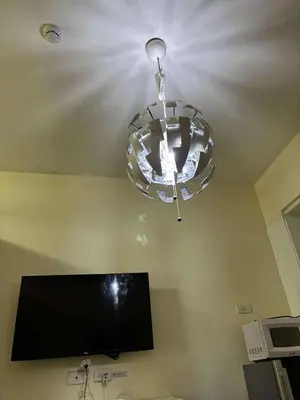a glass chandelier hanging from a ceiling with a tv at Seaside Stay in Manila