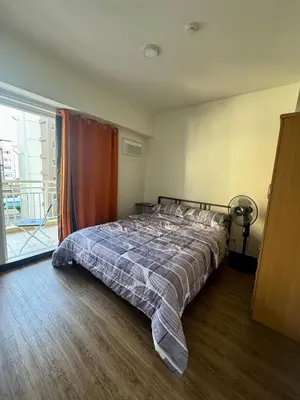 a bedroom with a bed in a room with a window at J Suite in Manila