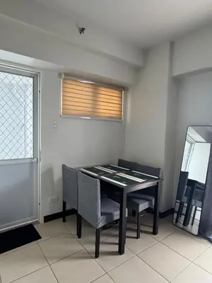 a dining room with a table and chairs and a window at J Suite in Manila