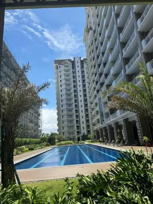 a swimming pool in front of a large apartment building at J Suite in Manila
