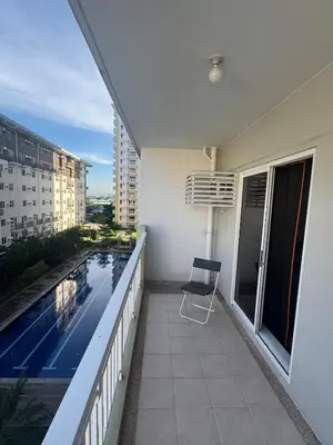 a balcony with a chair and a swimming pool at J Suite in Manila