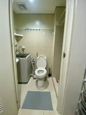 a small bathroom with a toilet and a sink at Cousins' Haven Staycation at SHELL RESIDENCES near MOA and NAIA in Manila