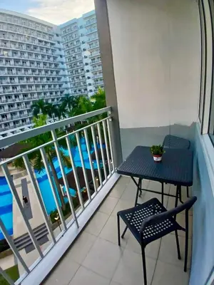a balcony with a table and a view of the ocean at Cousins' Haven Staycation at SHELL RESIDENCES near MOA and NAIA in Manila