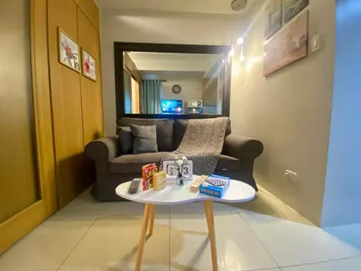 a living room with a couch and a table at Cousins' Haven Staycation at SHELL RESIDENCES near MOA and NAIA in Manila