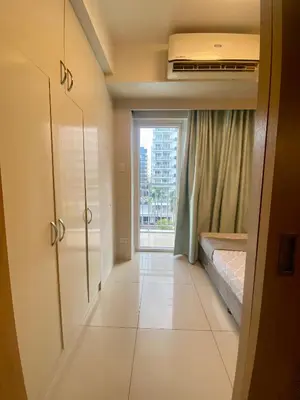a small bedroom with a bed and a window at Cousins' Haven Staycation at SHELL RESIDENCES near MOA and NAIA in Manila