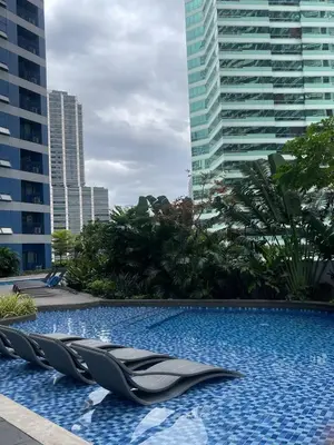 a swimming pool with chairs in the middle of a city at 