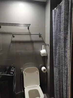 a bathroom with a toilet and a toilet paper dispenser at 