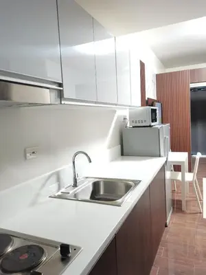 a white kitchen with a sink and a refrigerator at 
