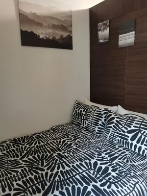 a bedroom with a bed with a black and white comforter at 