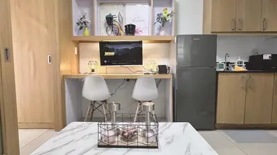 a kitchen with two chairs and a desk with a computer at Staycapades at Shell Residences in Manila