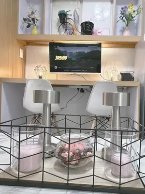 a room with two chairs and a television on a desk at Staycapades at Shell Residences in Manila