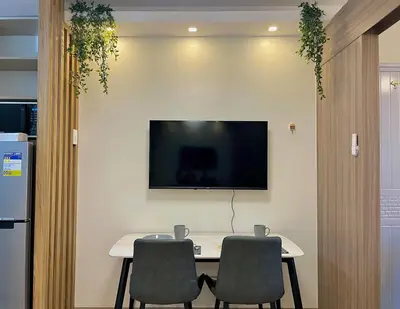 a table with two chairs and a television on a wall at Liwayway Suites in Manila