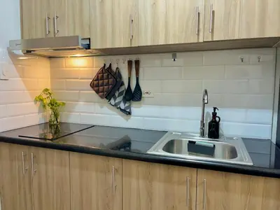 a kitchen with a sink and a counter top at Liwayway Suites in Manila