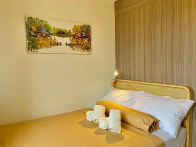 a bedroom with a bed with two towels on it at Liwayway Suites in Manila