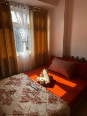 a bedroom with a bed with a window and a stuffed animal on it at PaulBert's Cabins II in Sampong